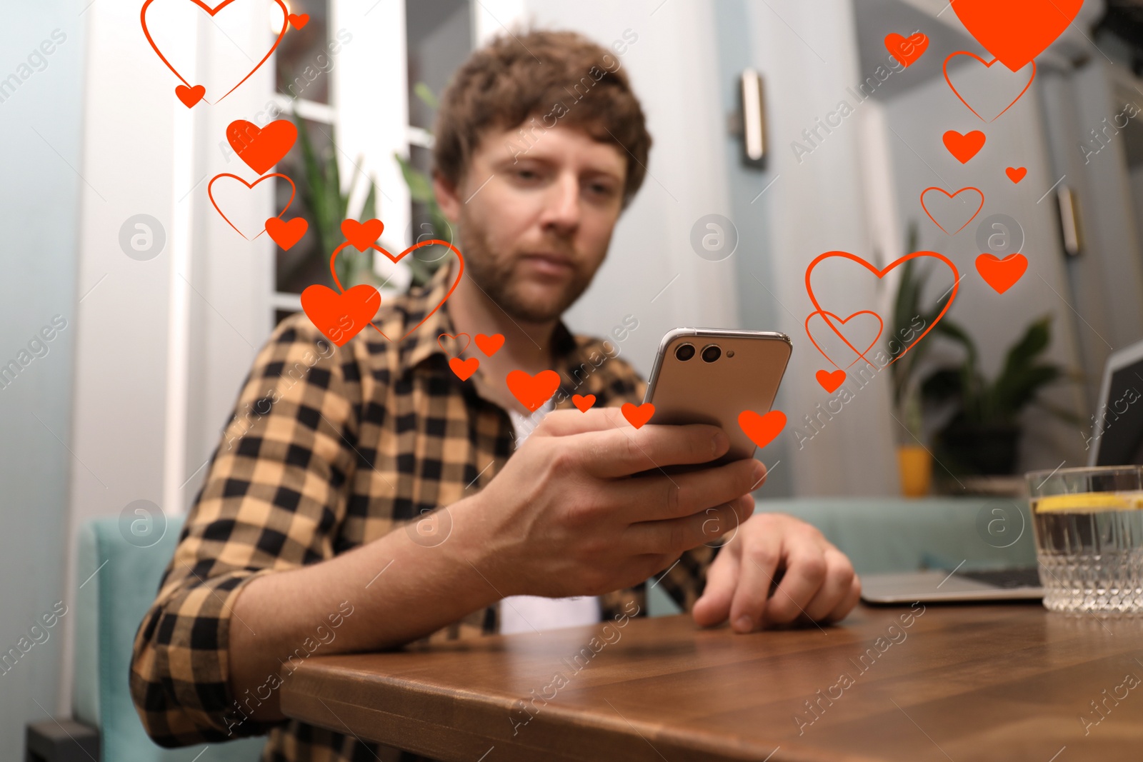 Image of Man visiting dating site via smartphone in cafe