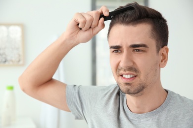 Photo of Young man with hair loss problem indoors