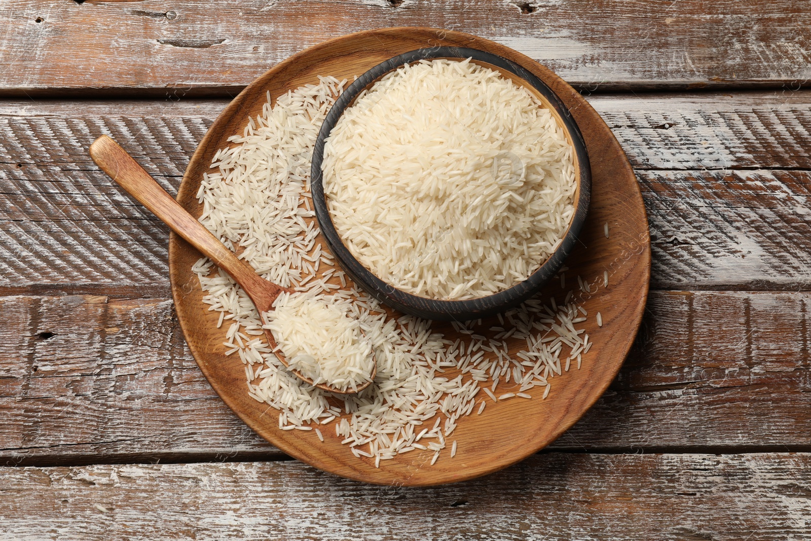 Photo of Raw basmati rice on wooden table, top view