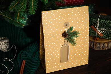 Composition with beautifully decorated Christmas present on wooden table