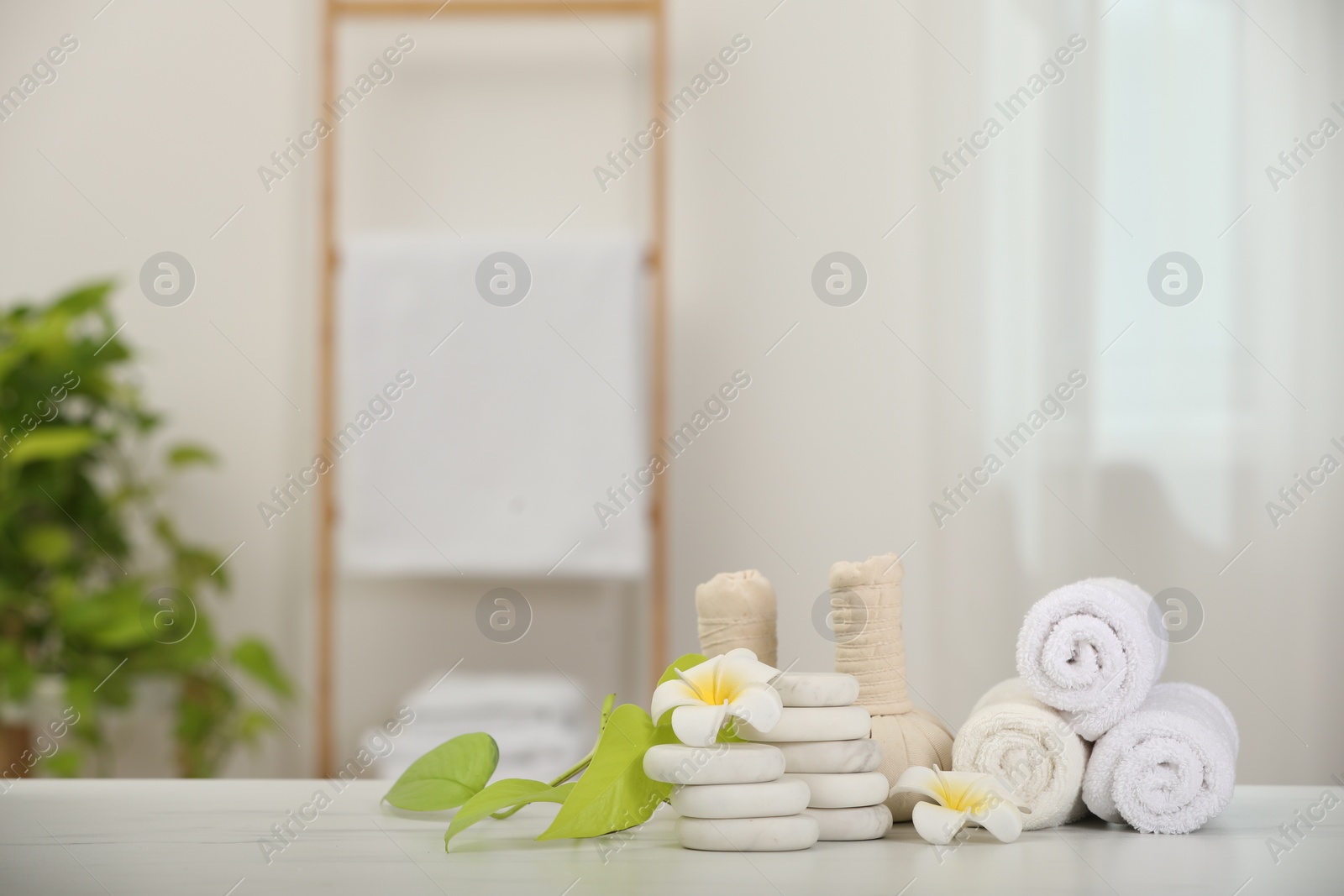 Photo of Composition with different spa products and plumeria flowers on white marble table indoors, space for text