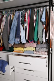 Rack with stylish women's clothes in room. Fast fashion