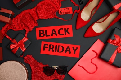 Photo of Gift boxes, women's underwear, accessories and phrase Black Friday on dark background, flat lay