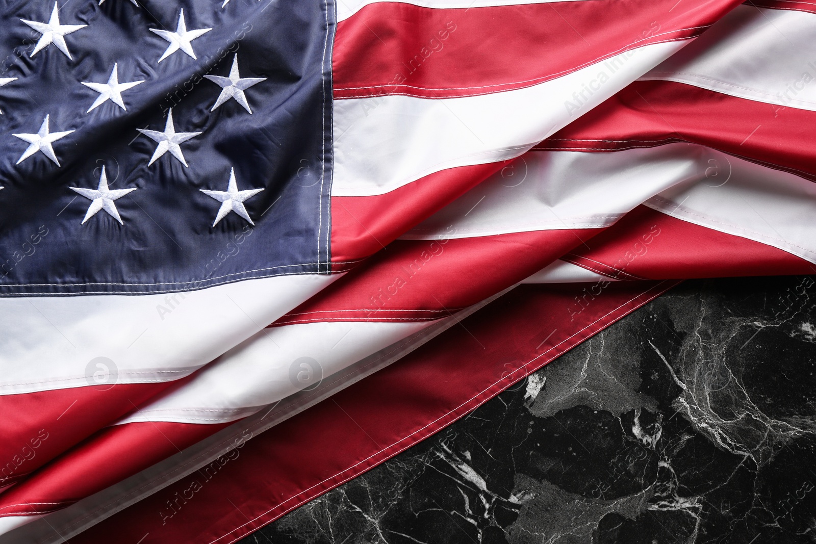 Photo of American flag on marble background, top view. Space for text