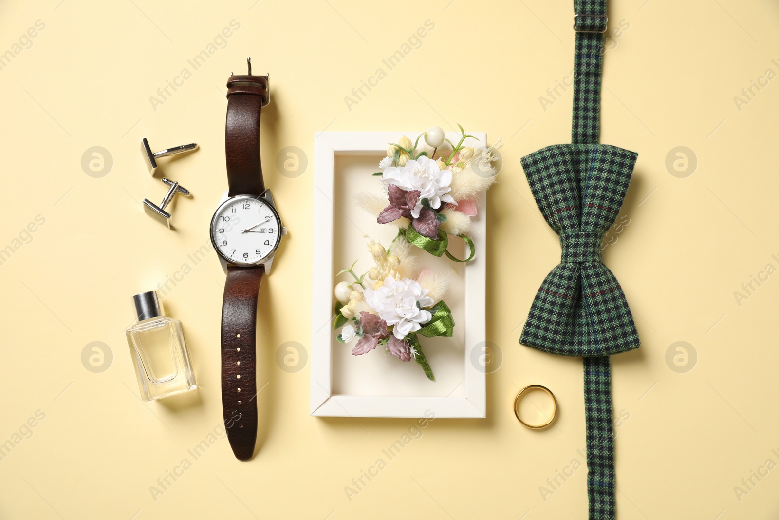 Photo of Wedding stuff. Flat lay composition with stylish boutonniere on yellow background