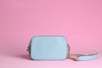 Stylish woman's bag on light pink background