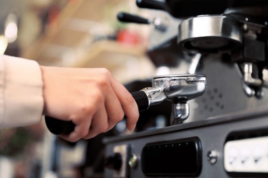 Photo of Barista preparing coffee using modern machine, closeup