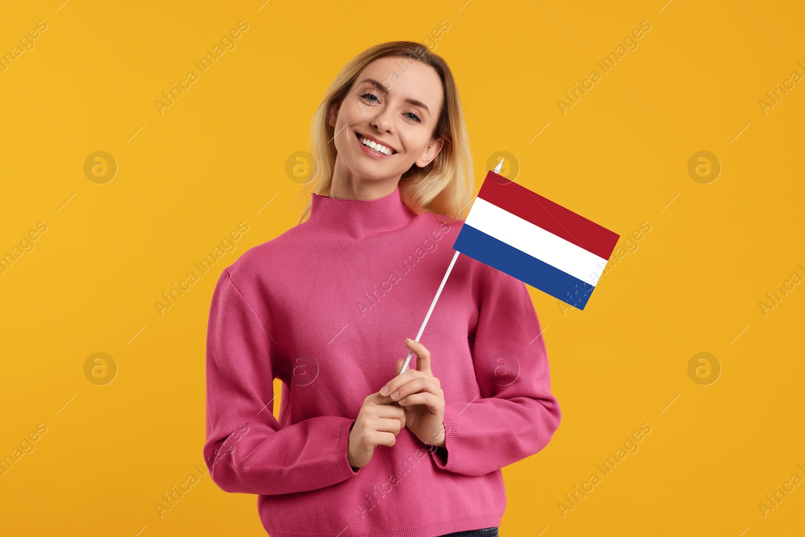 Image of Happy young woman with flag of France on yellow background