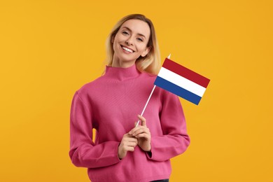 Image of Happy young woman with flag of France on yellow background