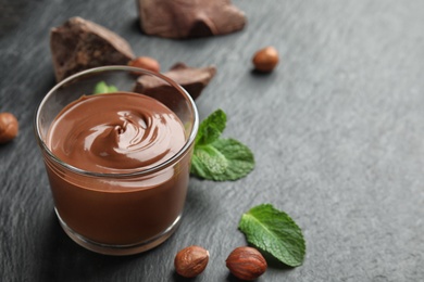 Composition with sweet chocolate mousse in glass on table. Space for text