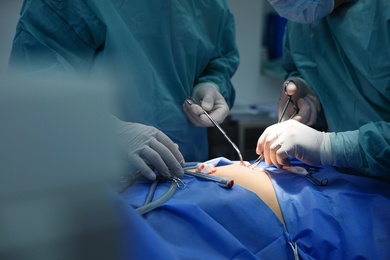 Medical team performing surgery in operating room, closeup