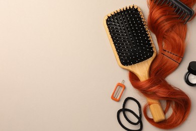Photo of Wooden brush, comb and red hair strand on light background, flat lay. Space for text