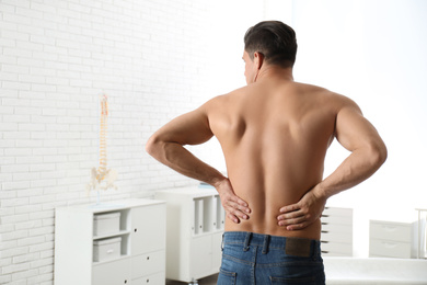 Photo of Man suffering from lower back pain at clinic. Visiting orthopedist