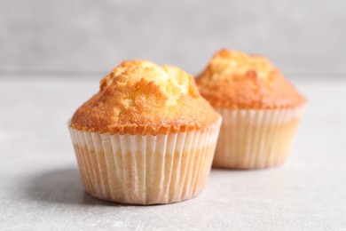 Photo of Tasty muffins on light grey table, closeup. Fresh pastry