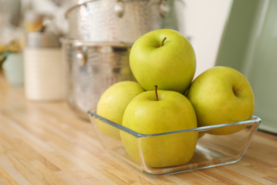 Photo of Apples in fruit bowl on wooden countertop in kitchen. Interior element