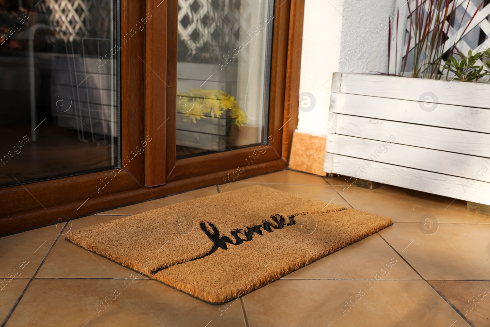 Photo of Doormat with word Home near entrance outdoors