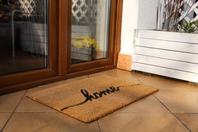 Doormat with word Home near entrance outdoors