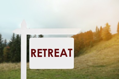 Image of Wooden sign with word Retreat and beautiful view of mountain landscape