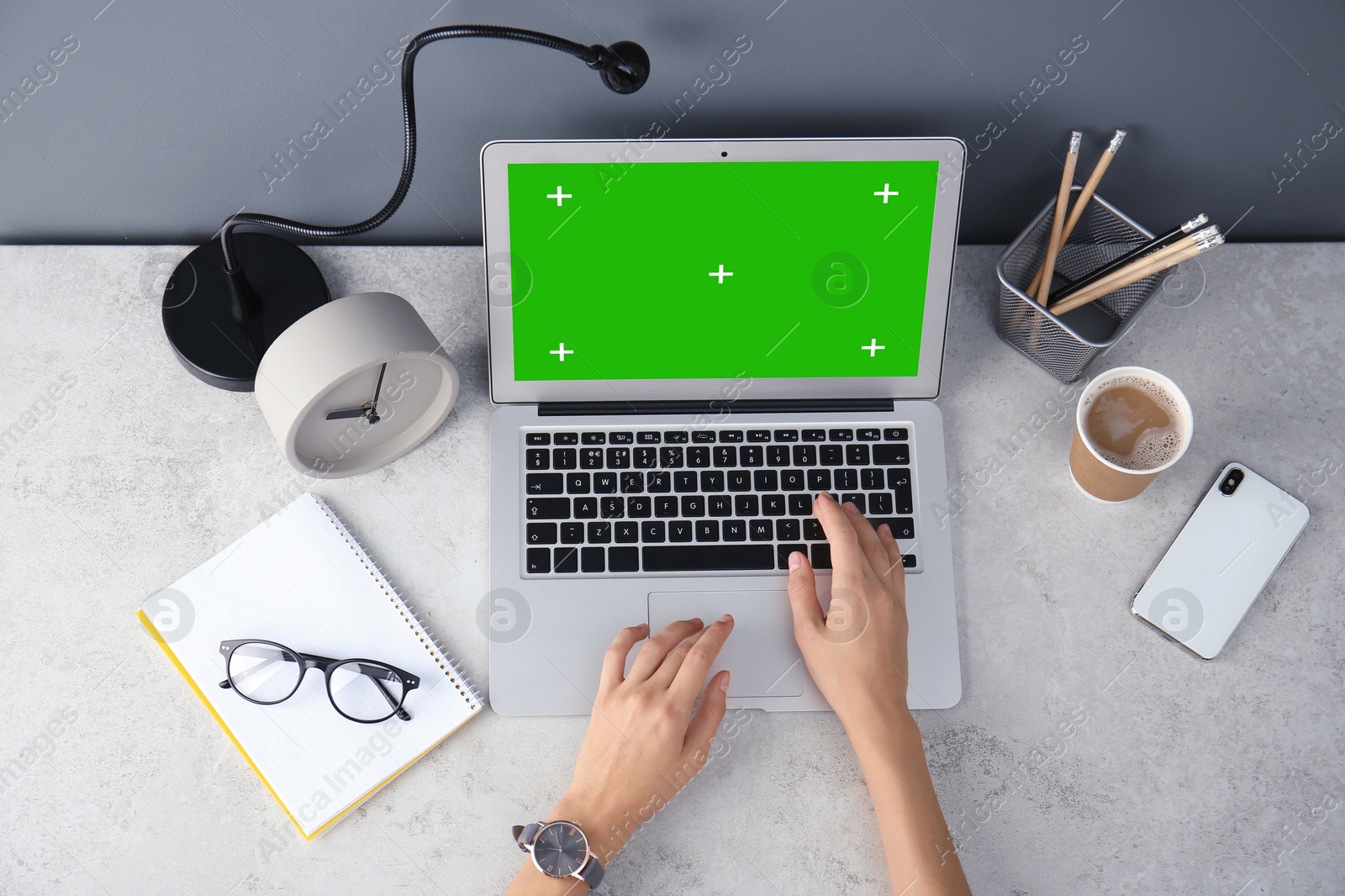 Image of Young woman using laptop at desk, top view. Device display with chroma key