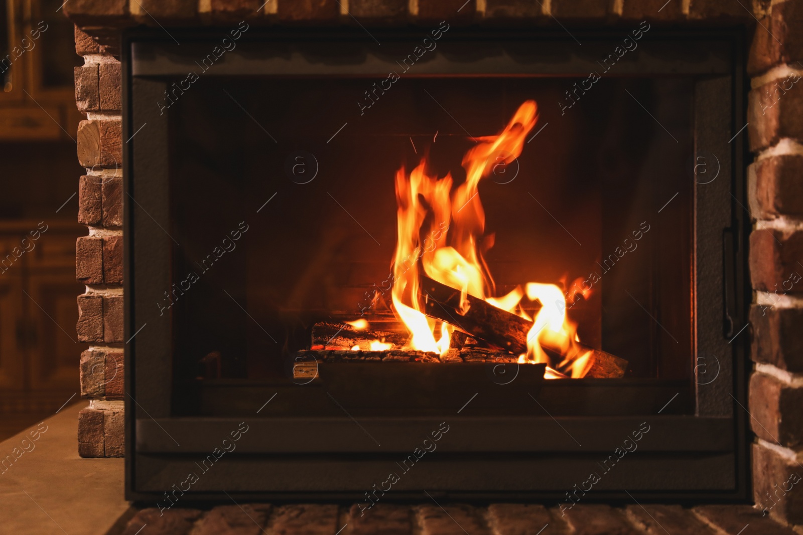 Photo of Fireplace with burning wood indoors. Winter vacation