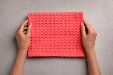 Woman with kitchen towel on stone surface, top view