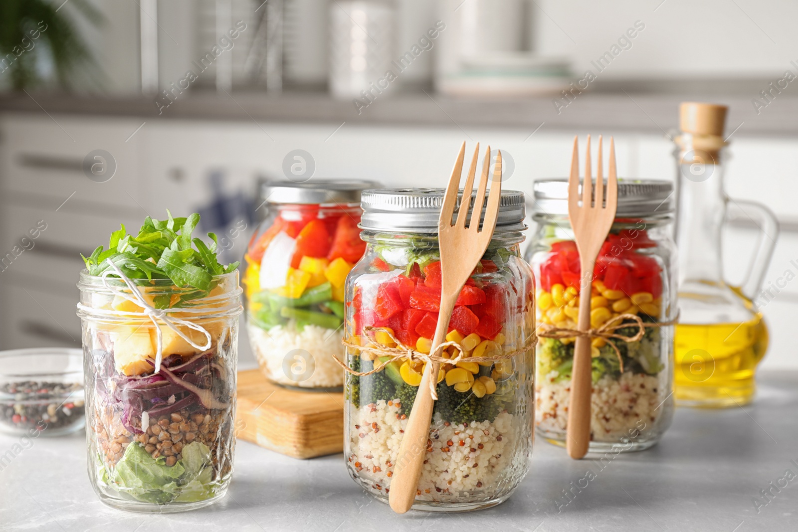 Photo of Glass jars with healthy meal on light grey marble table