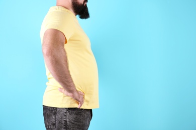 Fat man on color background, space for text. Weight loss