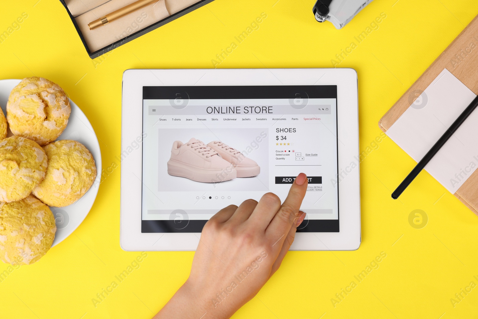 Photo of Woman with tablet shopping online on yellow background, top view