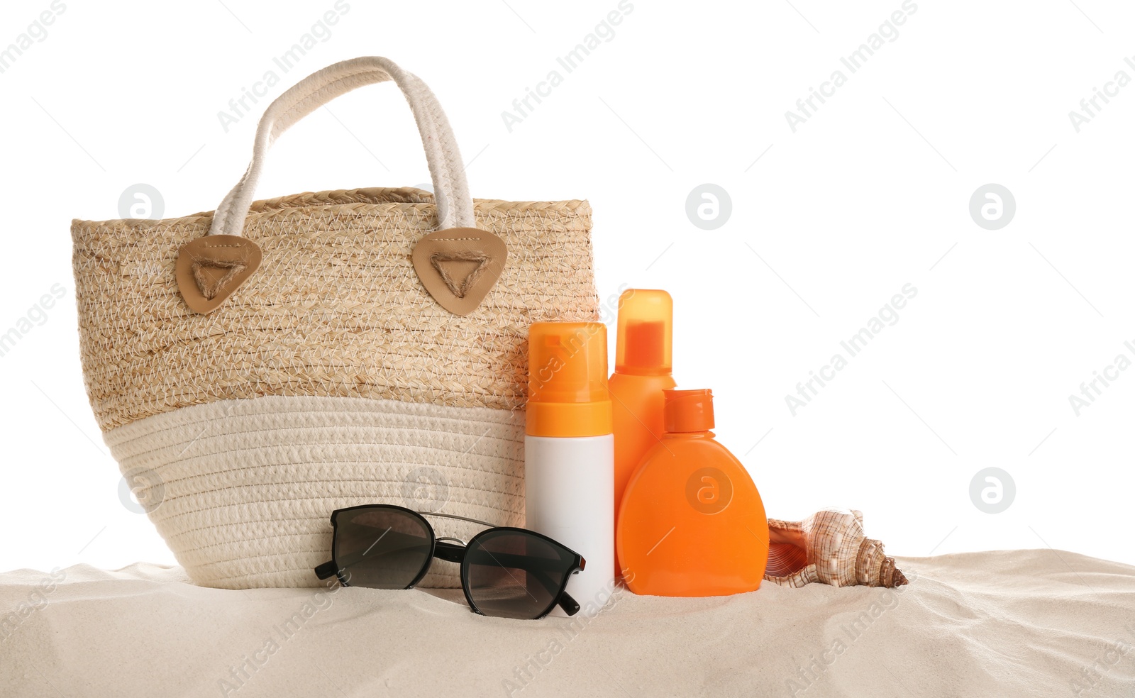 Photo of Stylish bag and different beach accessories on sand against white background
