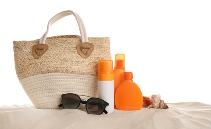 Stylish bag and different beach accessories on sand against white background