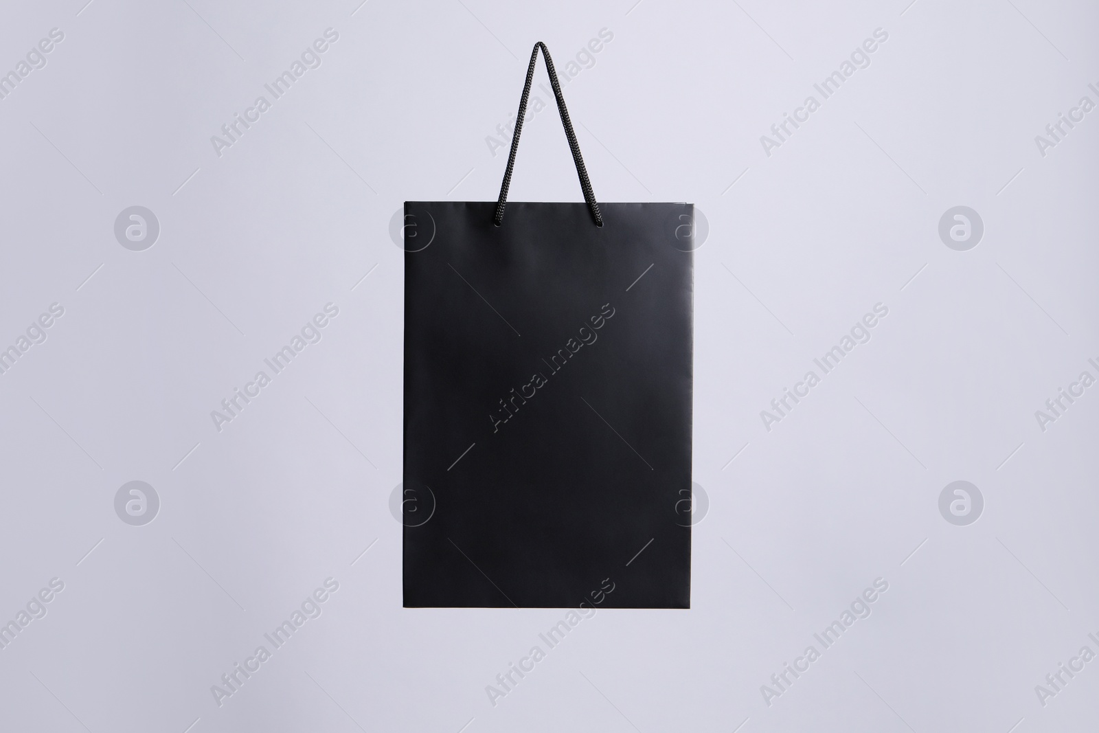 Photo of One black paper shopping bag on grey background