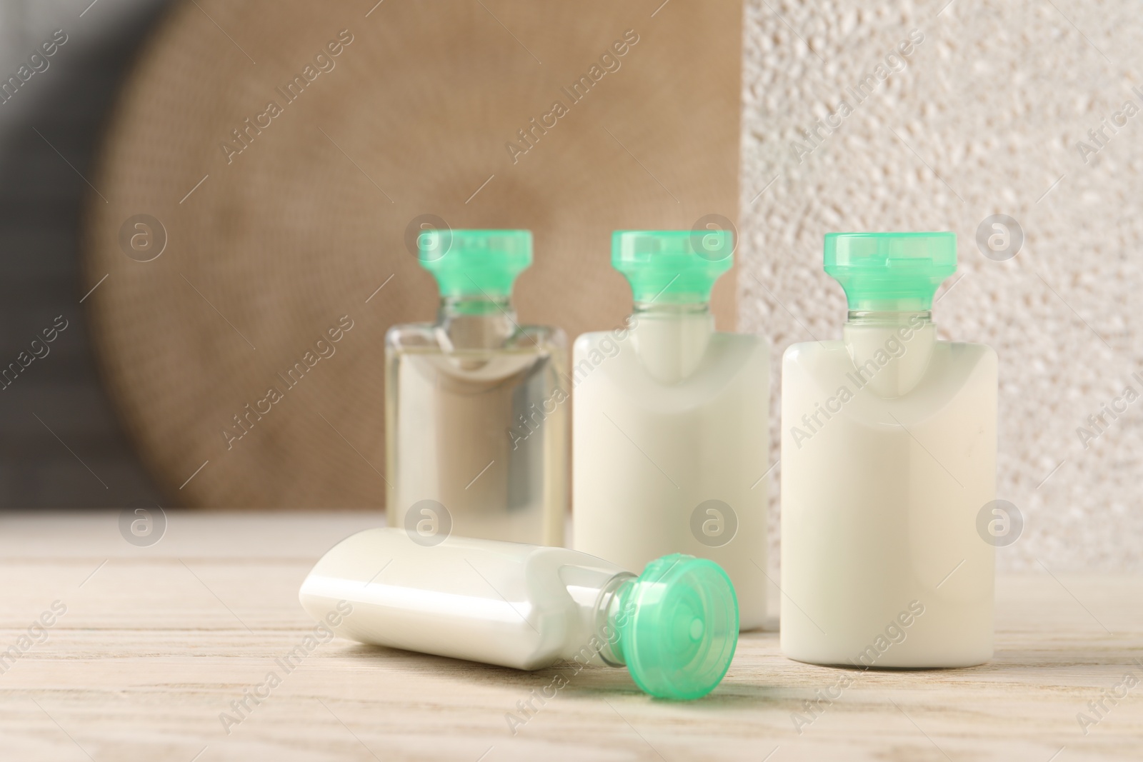 Photo of Mini bottles of cosmetic products on white wooden table, space for text