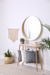 Photo of Round mirror and wooden table at home. Idea for interior design