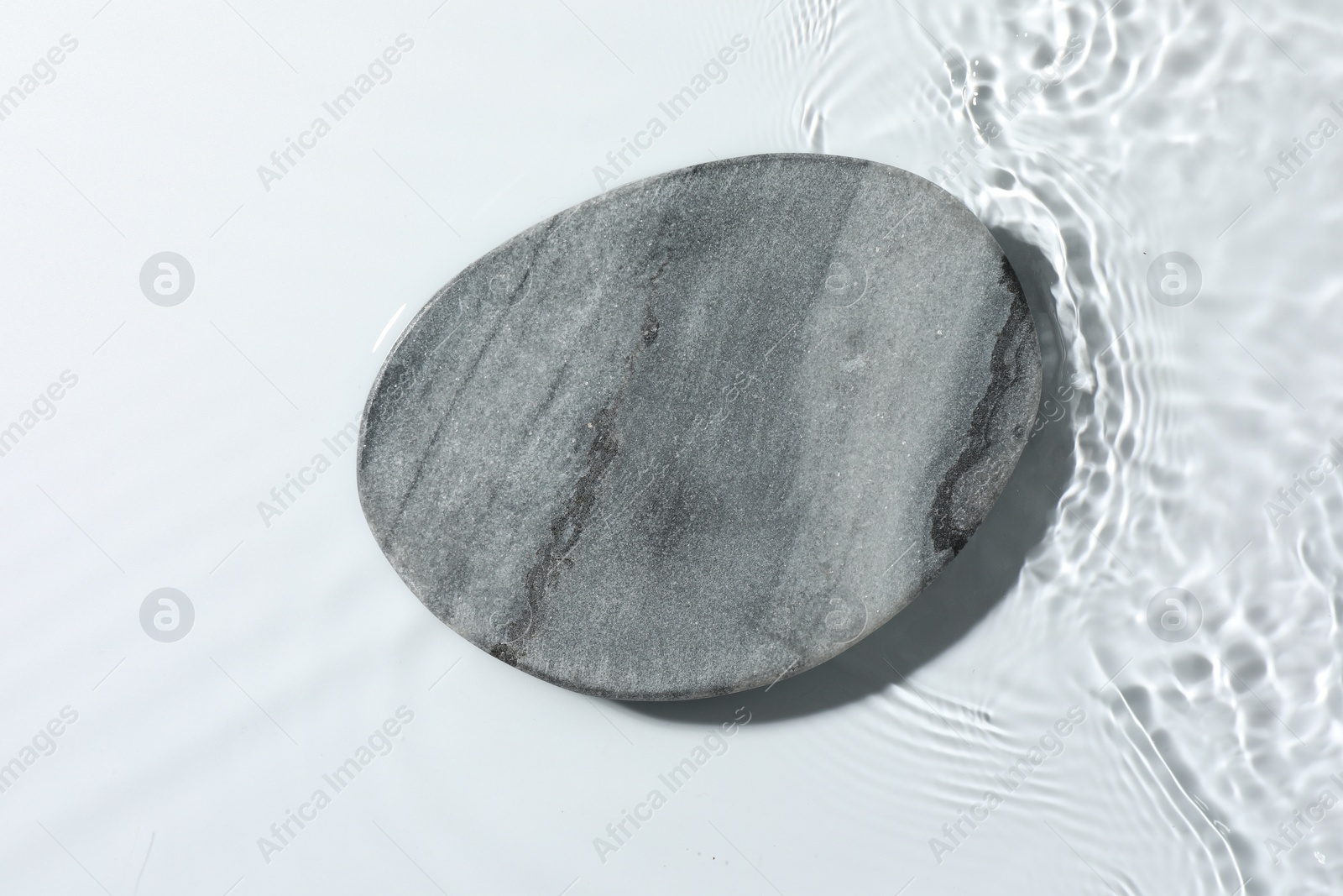 Photo of Presentation for product. Stone podium in water on white background, top view