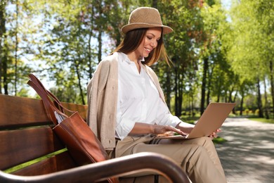 Beautiful woman working with laptop in park