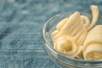 Photo of Gravy boat with butter curls on table, closeup