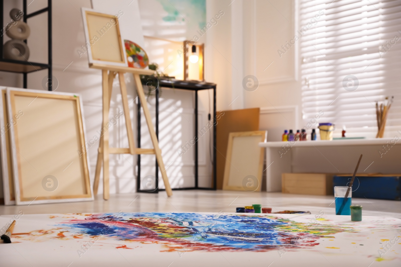 Photo of Abstract picture and wooden easel in art studio