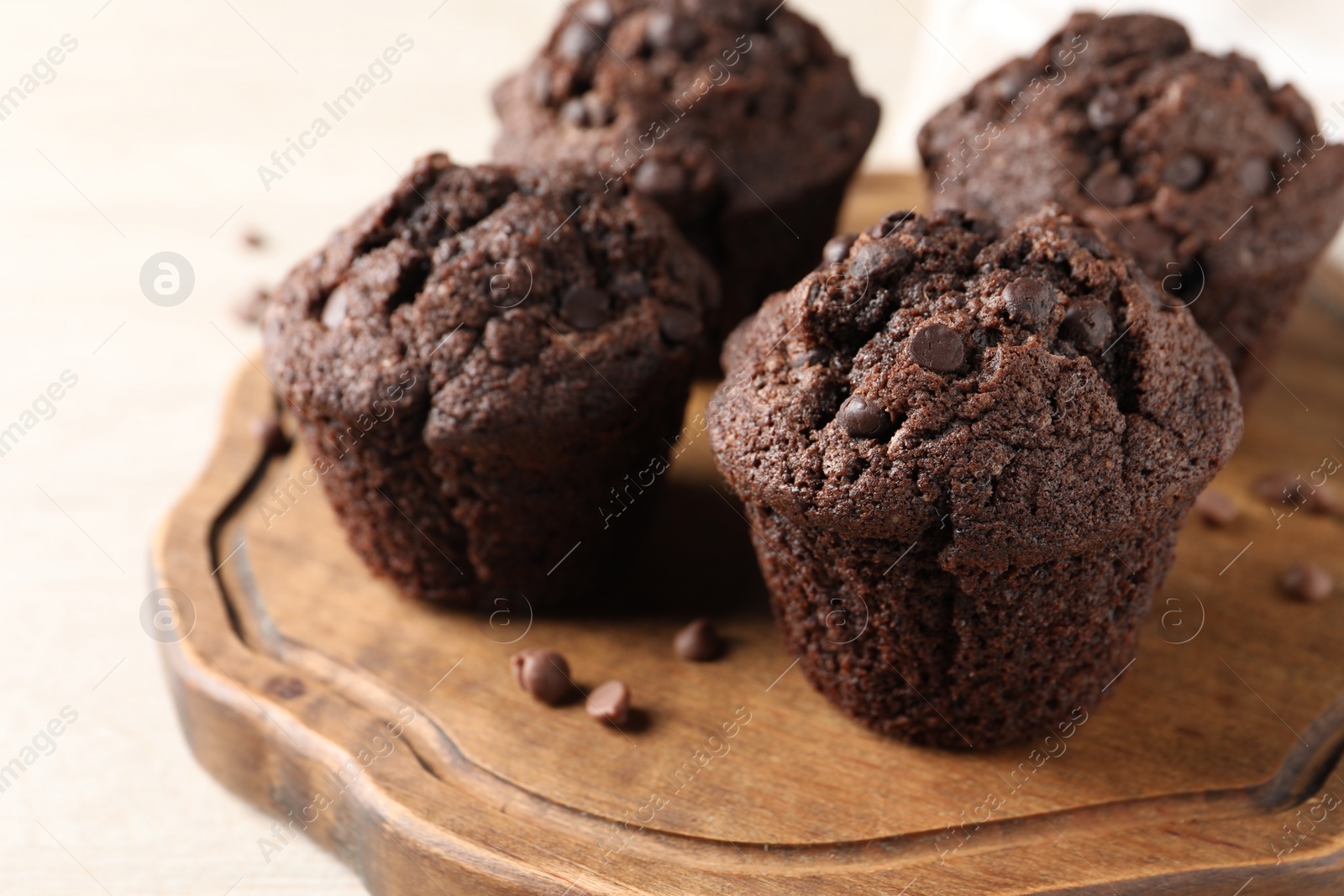 Photo of Delicious fresh chocolate muffins on white table, closeup. Space for text