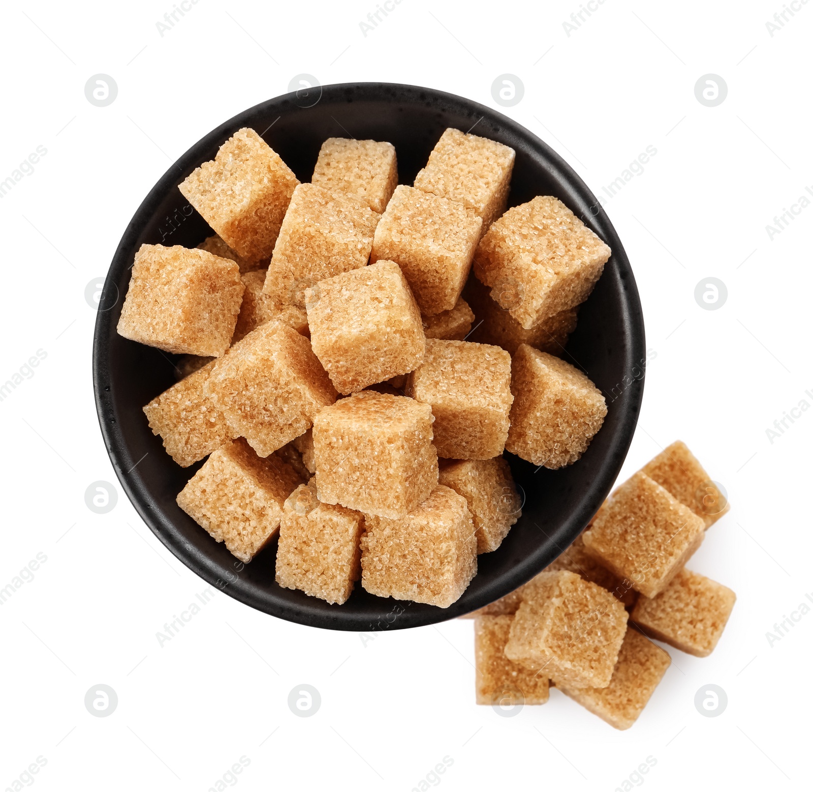 Photo of Bowl and brown sugar cubes on white background, top view