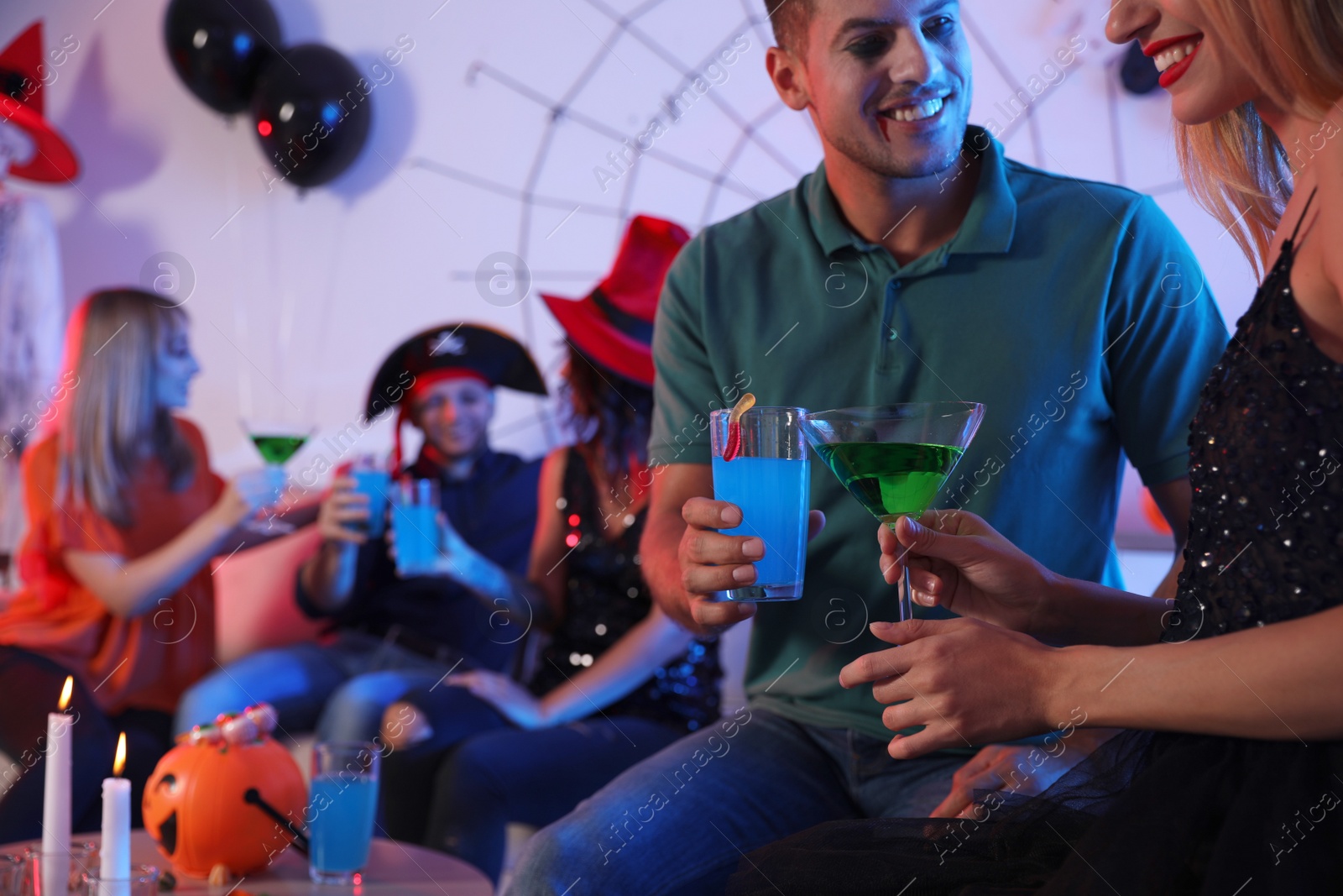 Photo of Couple with cocktails enjoying Halloween party at home