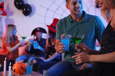 Couple with cocktails enjoying Halloween party at home