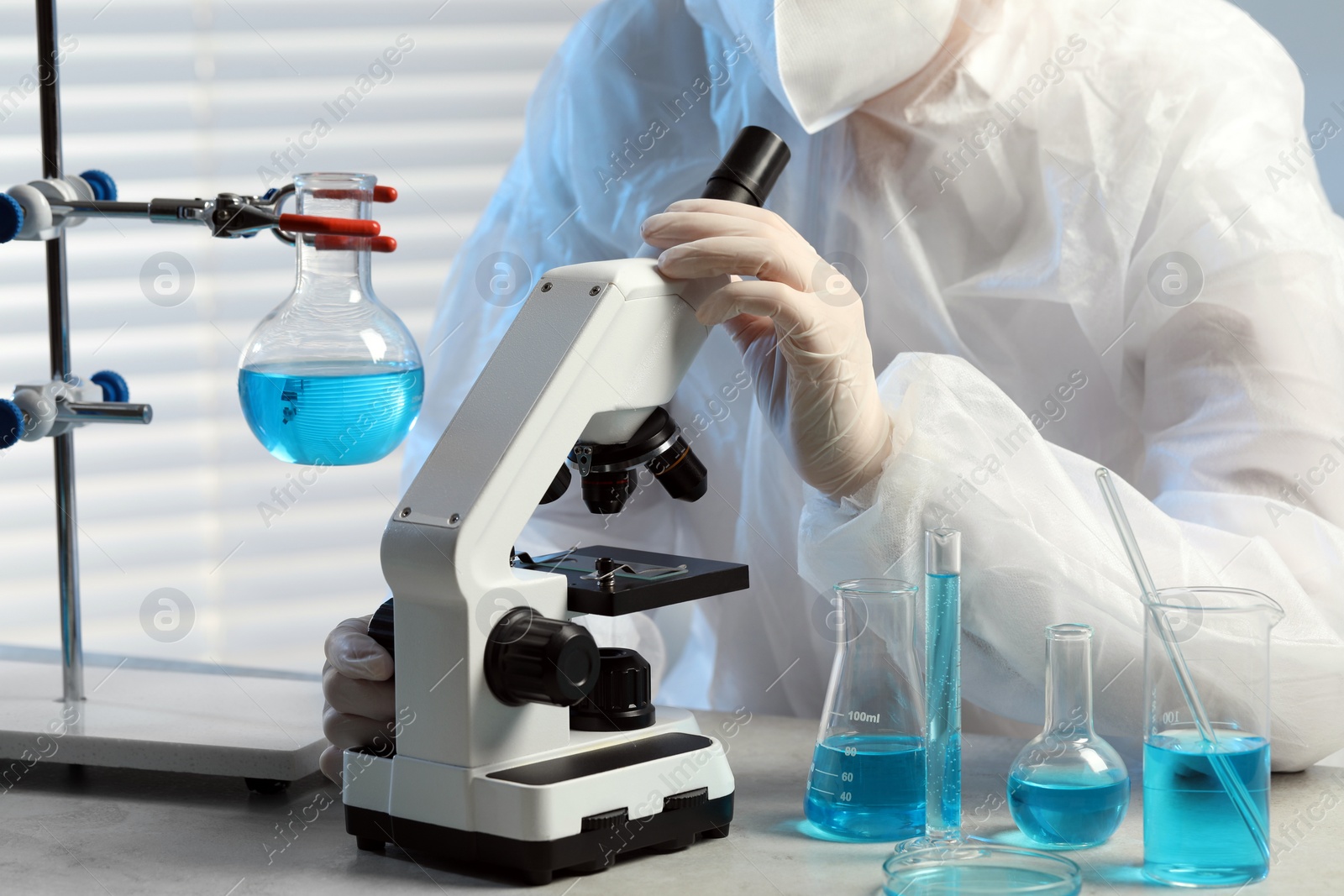 Photo of Scientist working with microscope in laboratory, closeup