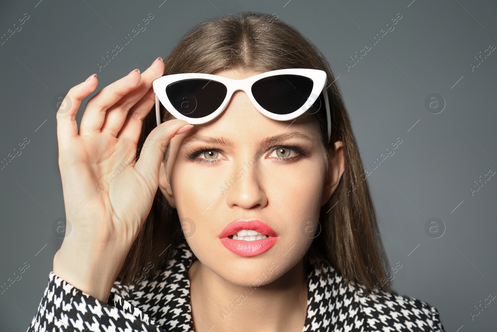 Photo of Young woman wearing stylish sunglasses on grey background