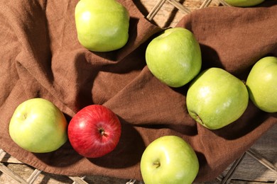 Photo of Fresh colorful apples on rattan grid, flat lay