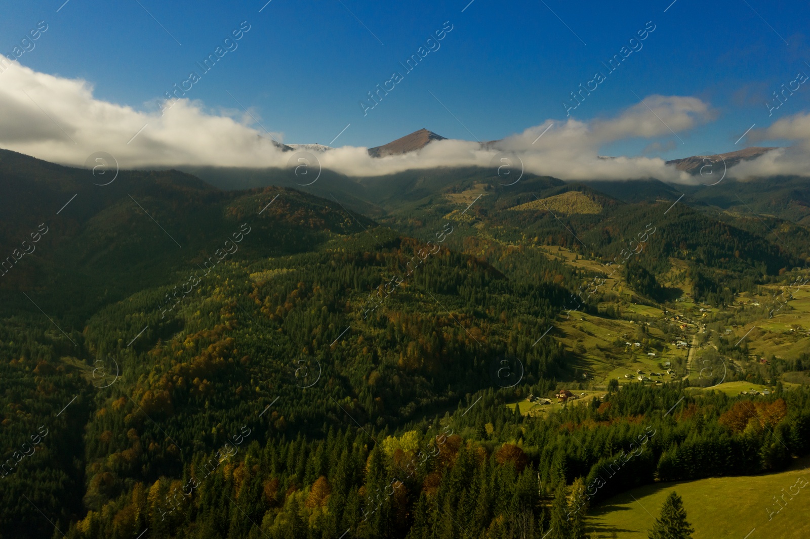 Image of Aerial view of beautiful mountain forest and village on autumn day