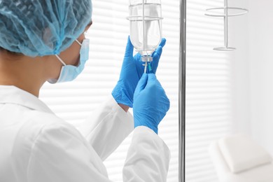 Photo of Nurse setting up IV drip in hospital, closeup