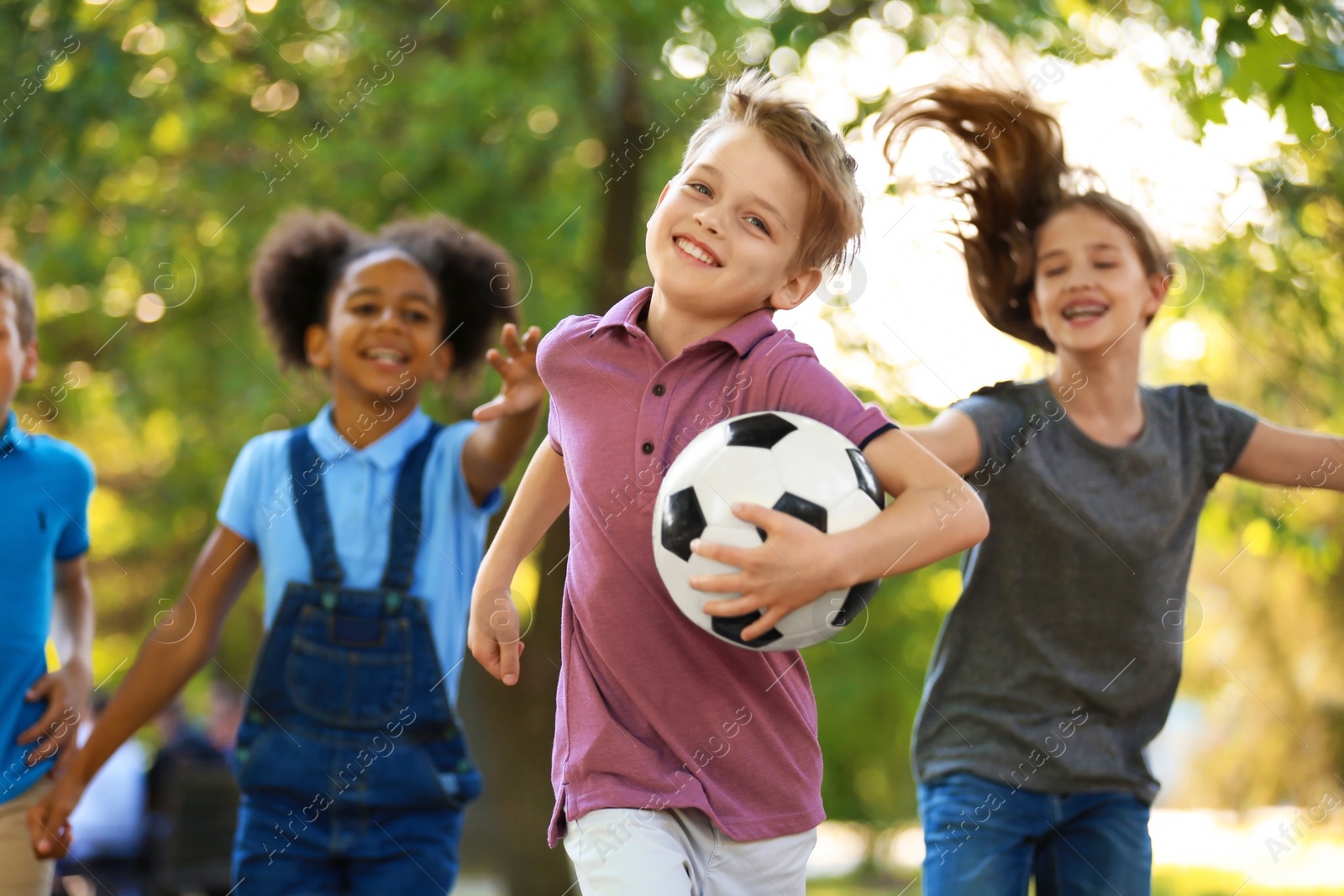 Photo of Cute little children playing with ball outdoors on sunny day