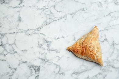 Photo of Fresh delicious puff pastry on white marble table, top view. Space for text