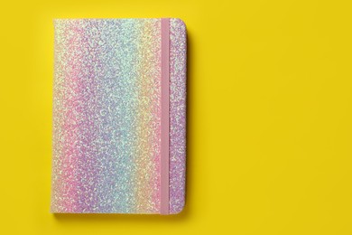 New stylish planner with hard cover on yellow background, top view. Space for text