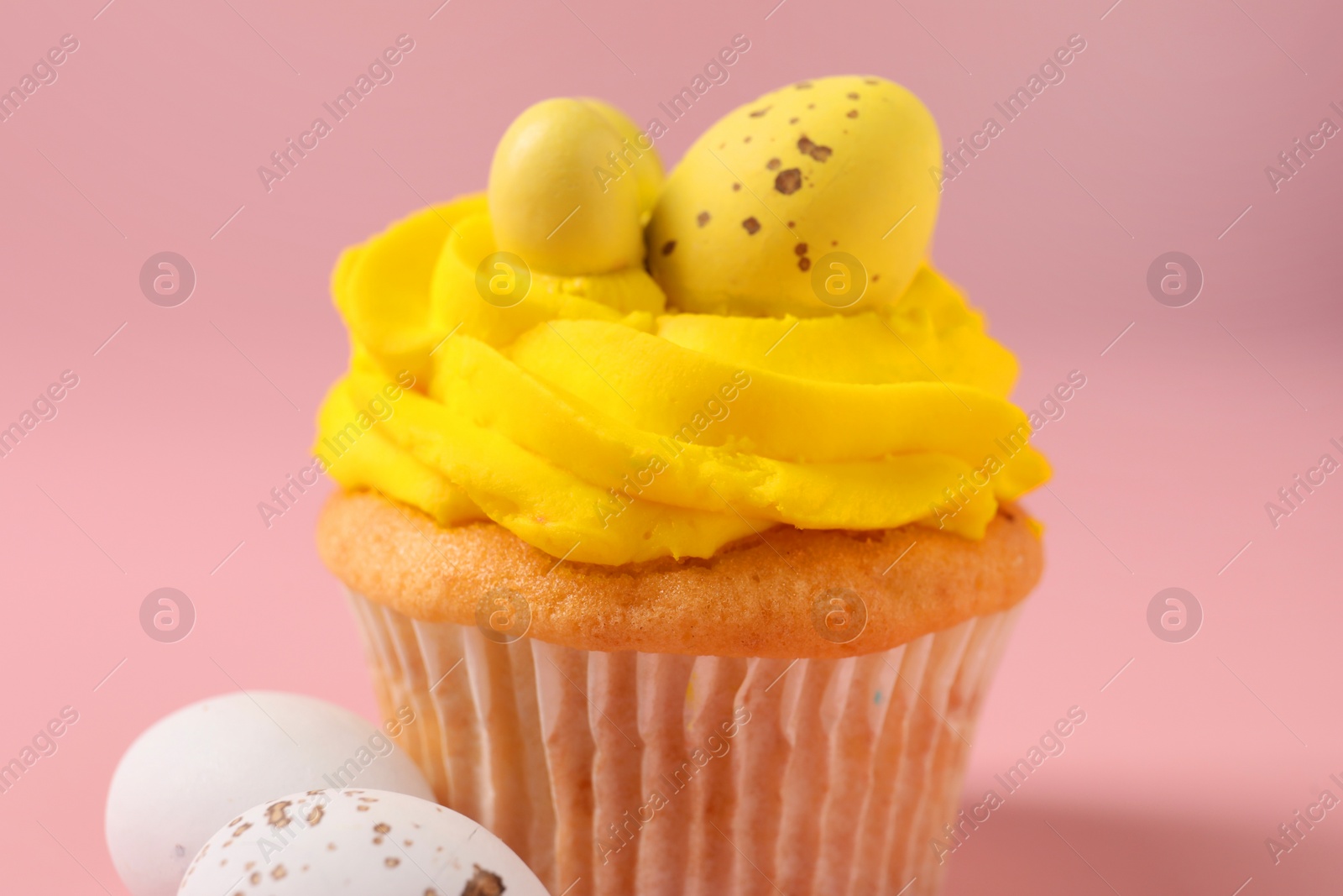 Photo of Tasty cupcake with Easter decor on pink background, closeup